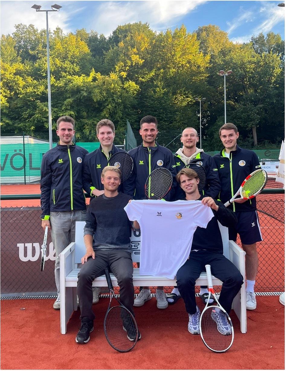 Gruppe von sechs Tennis-Spielern steht und sitzt auf einer Bank, mit Schlägern und einem Trikot in der Hand.